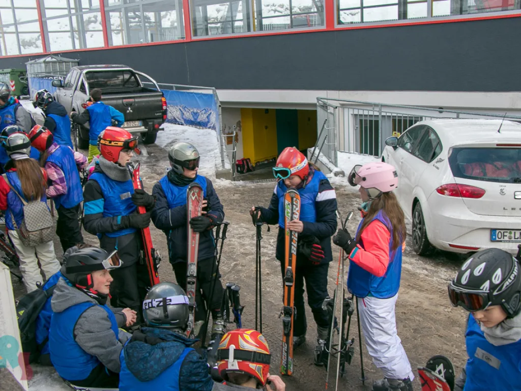 Jugendliche rüsten sich auf dem Parkplatz für die Piste.